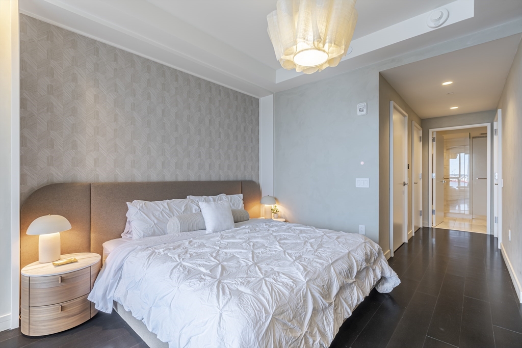 150 Seaport Boulevard, Unit 6D Boston, MA 02210 - Photo 15 of 30 a bedroom with a bed and wooden floor
