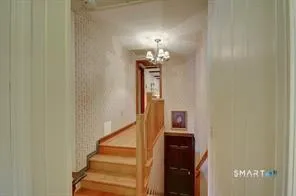 a view of a hallway with wooden floor and staircase