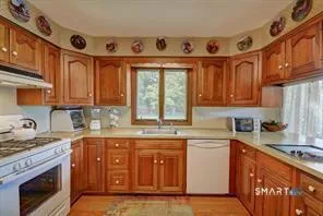 a kitchen with stainless steel appliances granite countertop a stove sink and cabinets