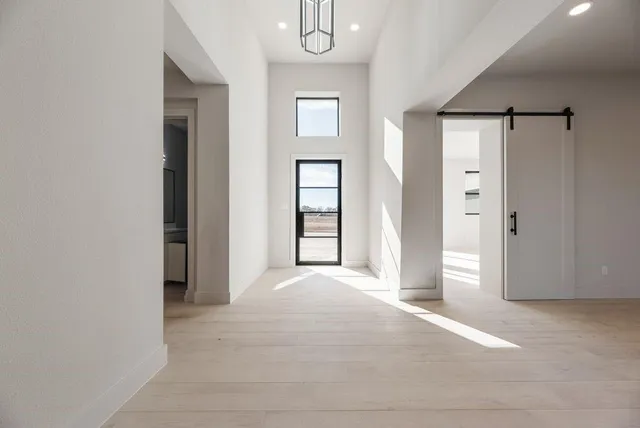 a view of an empty room with window and bathroom