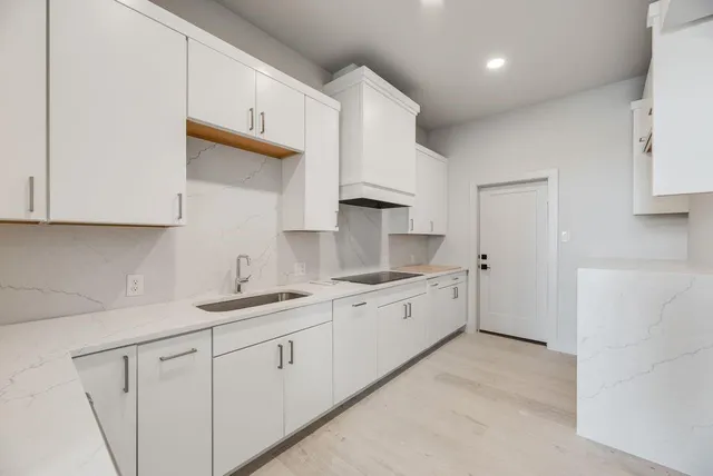 a kitchen with white cabinets stainless steel appliances and sink