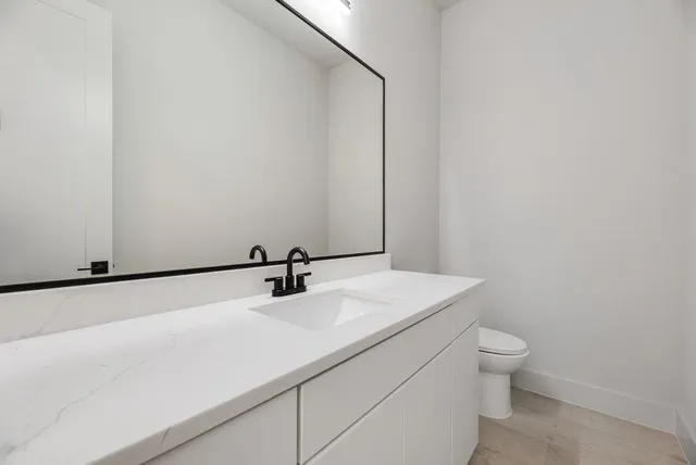 a bathroom with a sink a toilet and a mirror