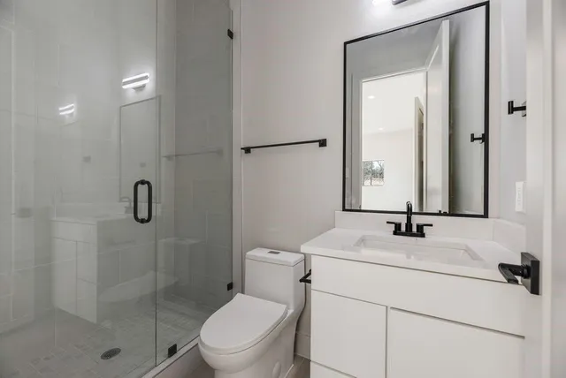 a bathroom with a sink toilet vanity and shower