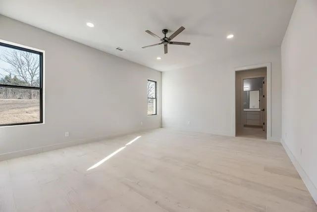 an empty room with fan and windows