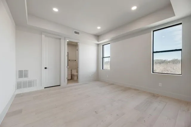 an empty room with windows and closet