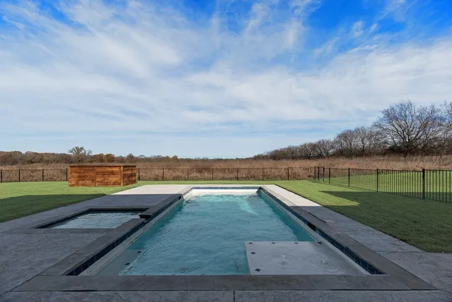 a view of swimming pool with a yard and large tree