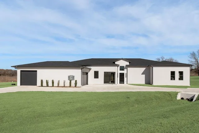 a front view of a house with a garden and yard