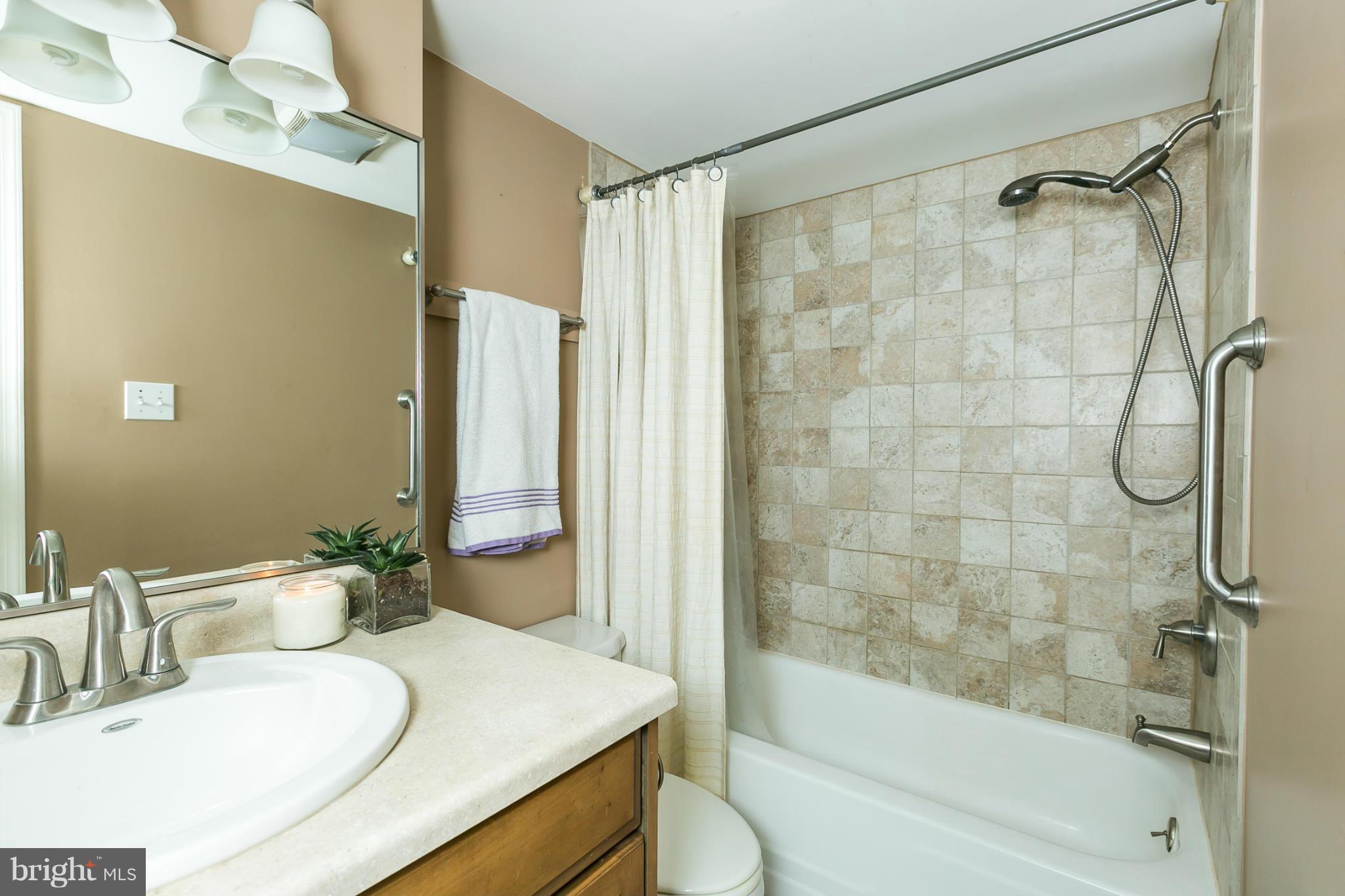 5235 West Running Brook Road, Unit 302 Columbia, MD 21044 - Photo 21 of 29 a bathroom with a granite countertop sink toilet and shower