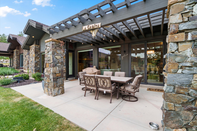 4892 Eagle Rdg Drive Eden, UT 84310 - Photo 26 of 39 Expansive outdoor living area featuring a concrete patio, a dark wood pergola, and stone pillars