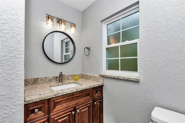 a bathroom with a granite countertop double vanity sink and a mirror