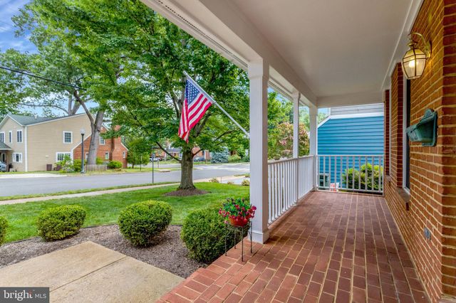 a kitchen with stainless steel appliances a stove top oven a sink a refrigerator white cabinets and wooden floor