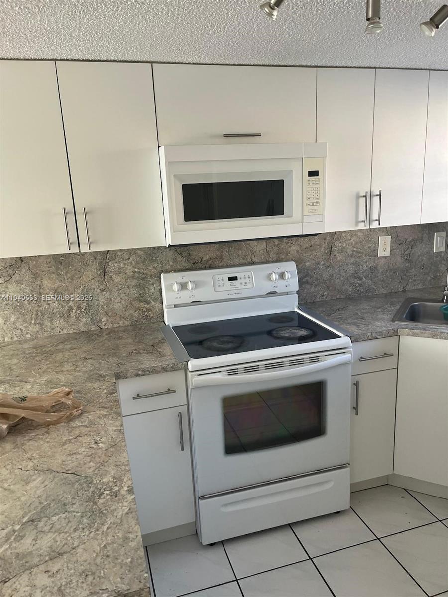 5580 West 26th Court, Unit 208 Hialeah, FL 33016 - Photo 11 of 12 a stove top oven sitting inside of a kitchen