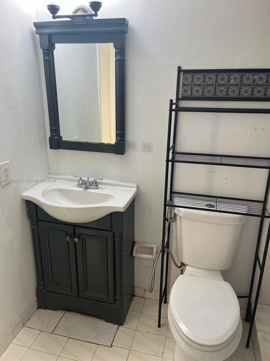 5580 West 26th Court, Unit 208 Hialeah, FL 33016 - Photo 3 of 12 a bathroom with a toilet sink and mirror