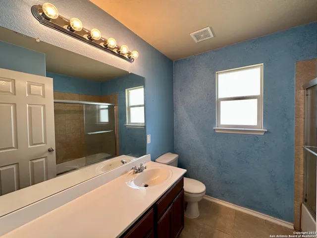 a bathroom with a sink a toilet and mirror
