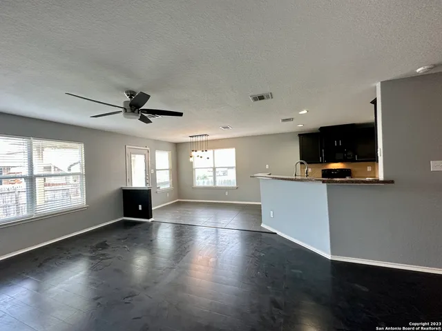 a kitchen with kitchen island granite countertop a sink counter top space appliances and cabinets