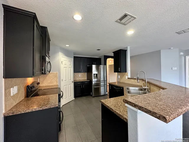 a kitchen with granite countertop a sink and cabinets