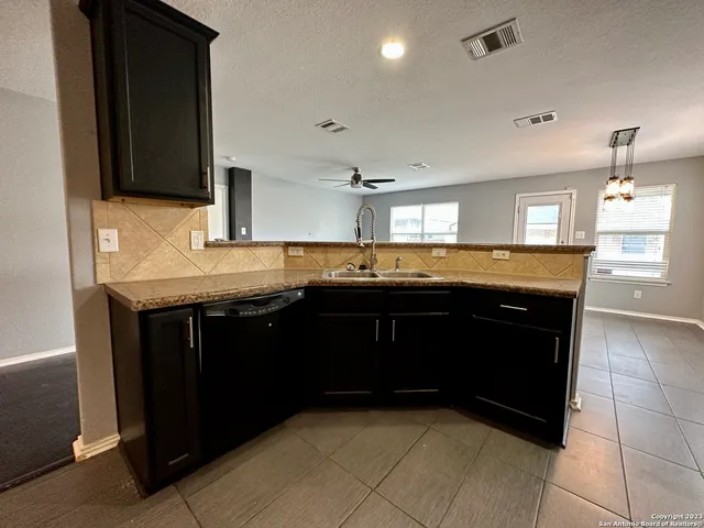 a large kitchen with stainless steel appliances granite countertop a stove a sink and a microwave