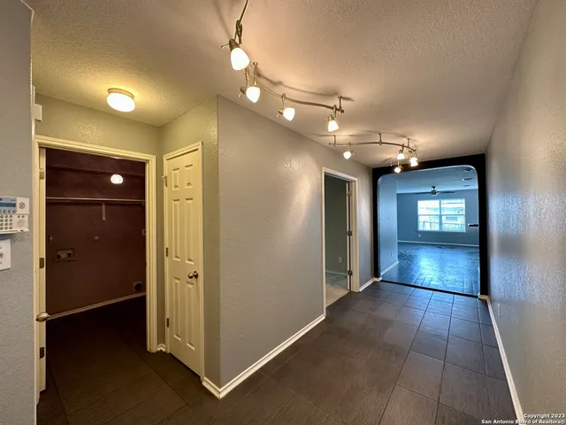 a view of a hallway with wooden shelves