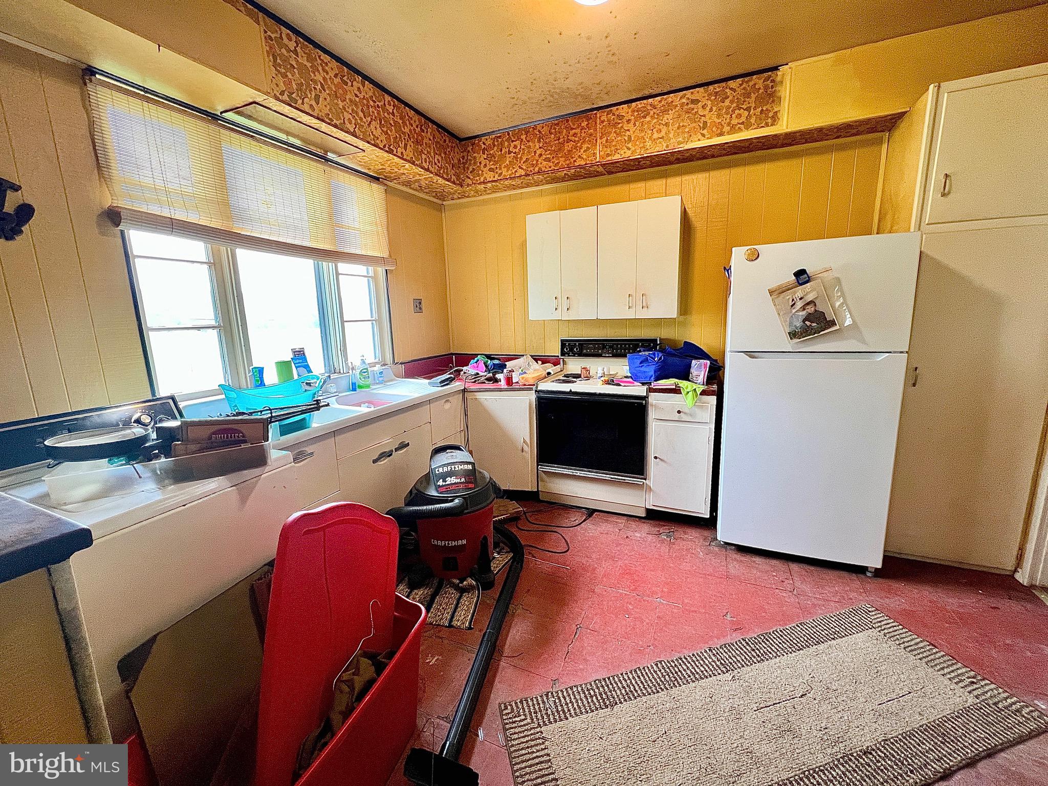 280 Fairview Street Tamaqua, PA 18252 - Photo 11 of 26 a kitchen with stainless steel appliances a stove a refrigerator a table and chairs with wooden floor