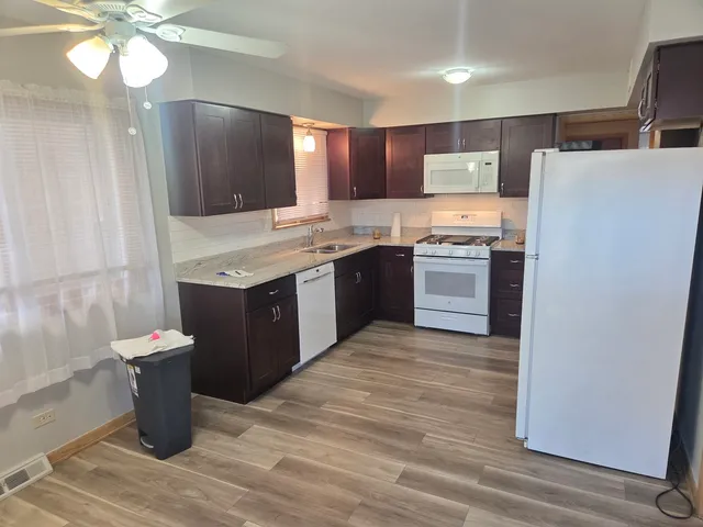 a view of kitchen with stainless steel appliances granite countertop cabinets and wooden floor