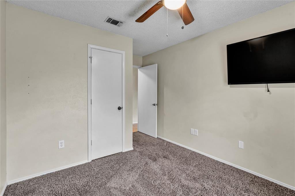 108 Prairie Creek Road Red Oak, TX 75154 - Photo 9 of 19 Carpeted room featuring a ceiling fan with integrated lighting, a wall-mounted television, and neutral-toned walls