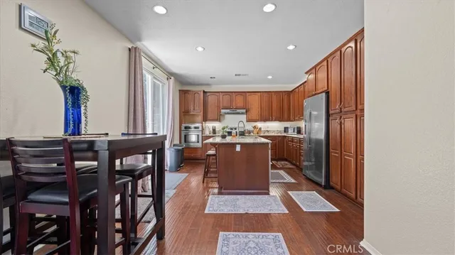 a kitchen with stainless steel appliances granite countertop a refrigerator and a stove top oven