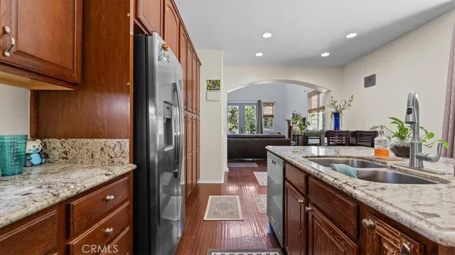 a bathroom with a granite countertop sink a toilet and a window