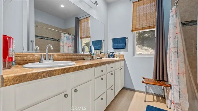 a bathroom with a granite countertop sink a toilet and shower