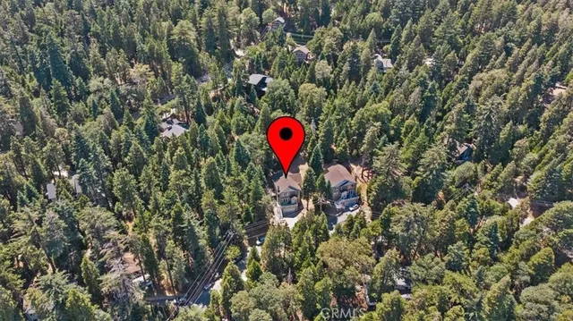 a front view of a house with a yard and a large tree