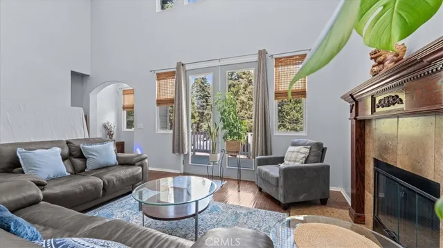 a kitchen with stainless steel appliances granite countertop a stove a refrigerator a sink a dining table and chairs with wooden floor