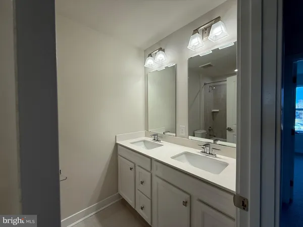 a bathroom with a double vanity sink and a mirror