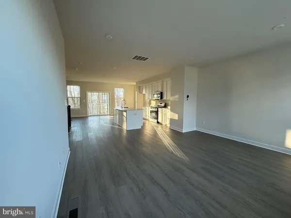 a view of empty room with wooden floor and windows