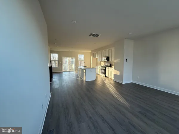 a view of a big room with wooden floor and windows