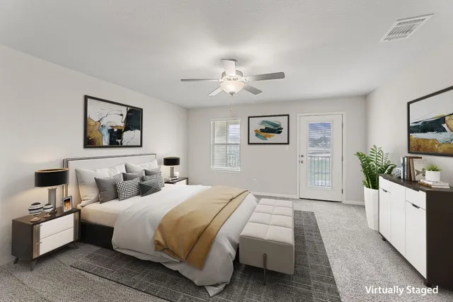 a spacious bedroom with a large bed and a chandelier