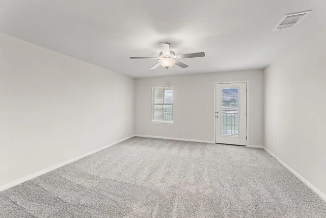 a view of an empty room with a ceiling fan