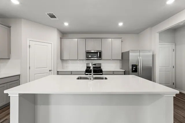 a kitchen with stainless steel appliances a microwave sink and refrigerator