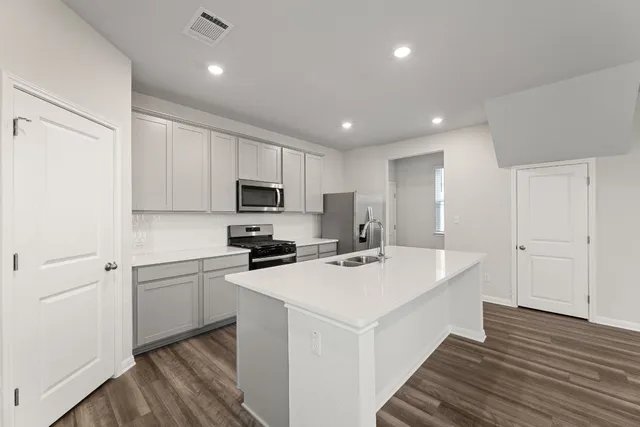 a kitchen with a sink a stove a refrigerator and cabinets