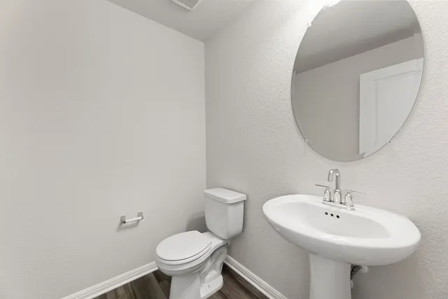 a bathroom with a sink a toilet and mirror