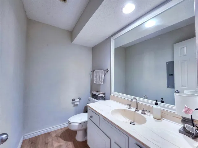 a bathroom with a sink vanity granite and toilet