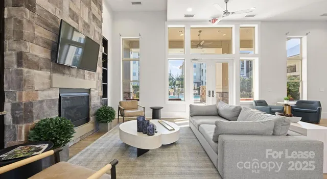 a living room with furniture fireplace and large windows