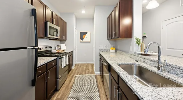 a kitchen with a sink stove top oven and refrigerator