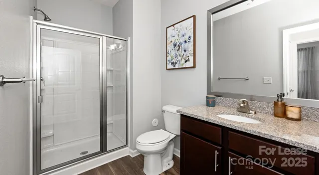 a bathroom with a granite countertop sink toilet and shower