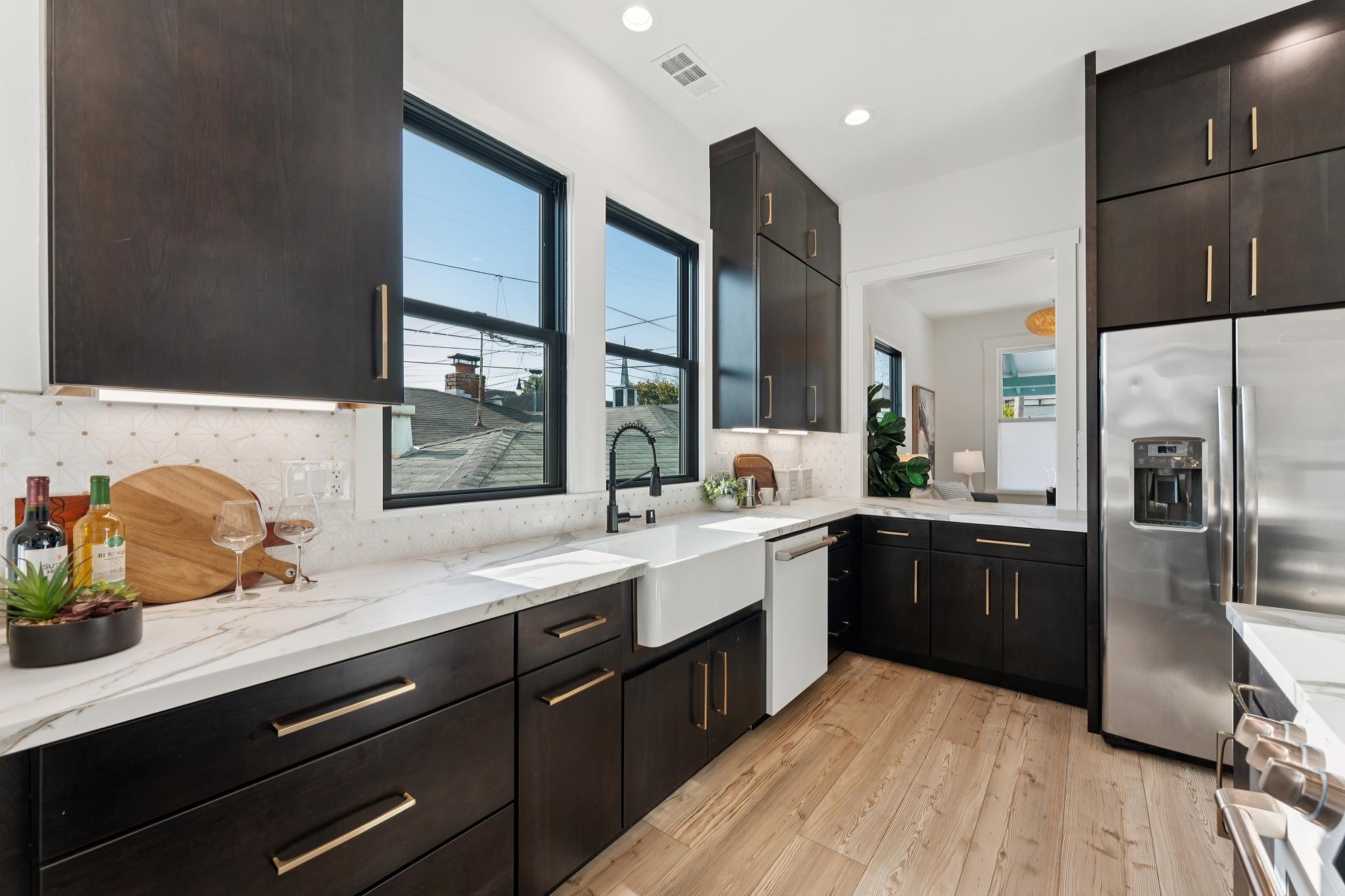 1308 Court Street Alameda, CA 94501 - Photo 31 of 60 Kitchen featuring stainless steel fridge with ice dispenser, light wood-style floors, backsplash, light stone counters, and dishwasher