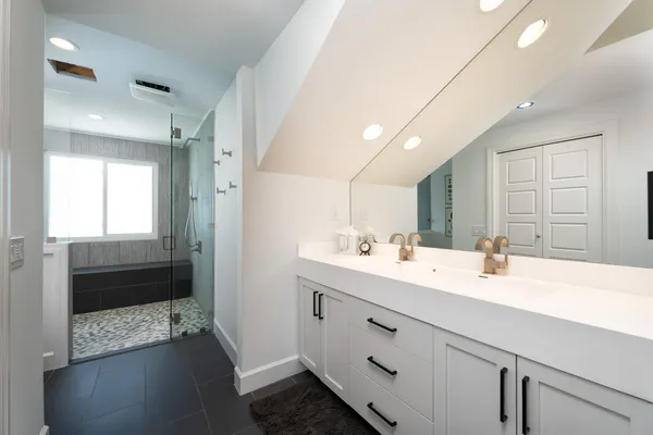 a bathroom with a sink a toilet and shower