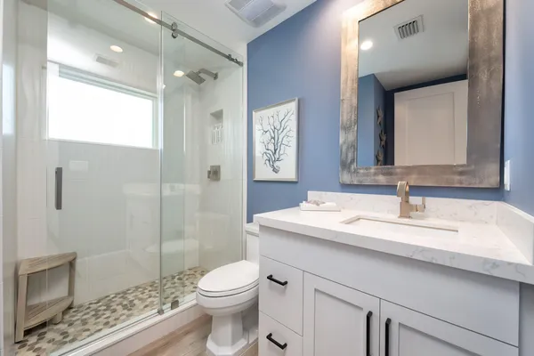 a bathroom with a sink a toilet and shower