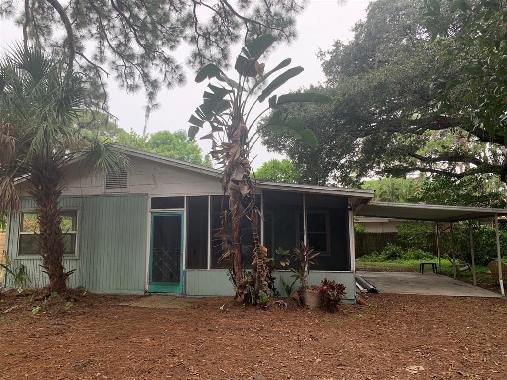 1063 40th Street Sarasota, FL 34234 - Photo 1 of 13 a view of backyard with potted plants and a large tree