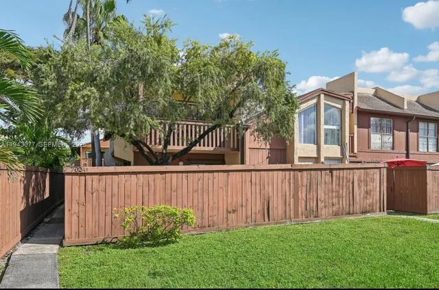 a view of a deck with a large trees and wooden fence