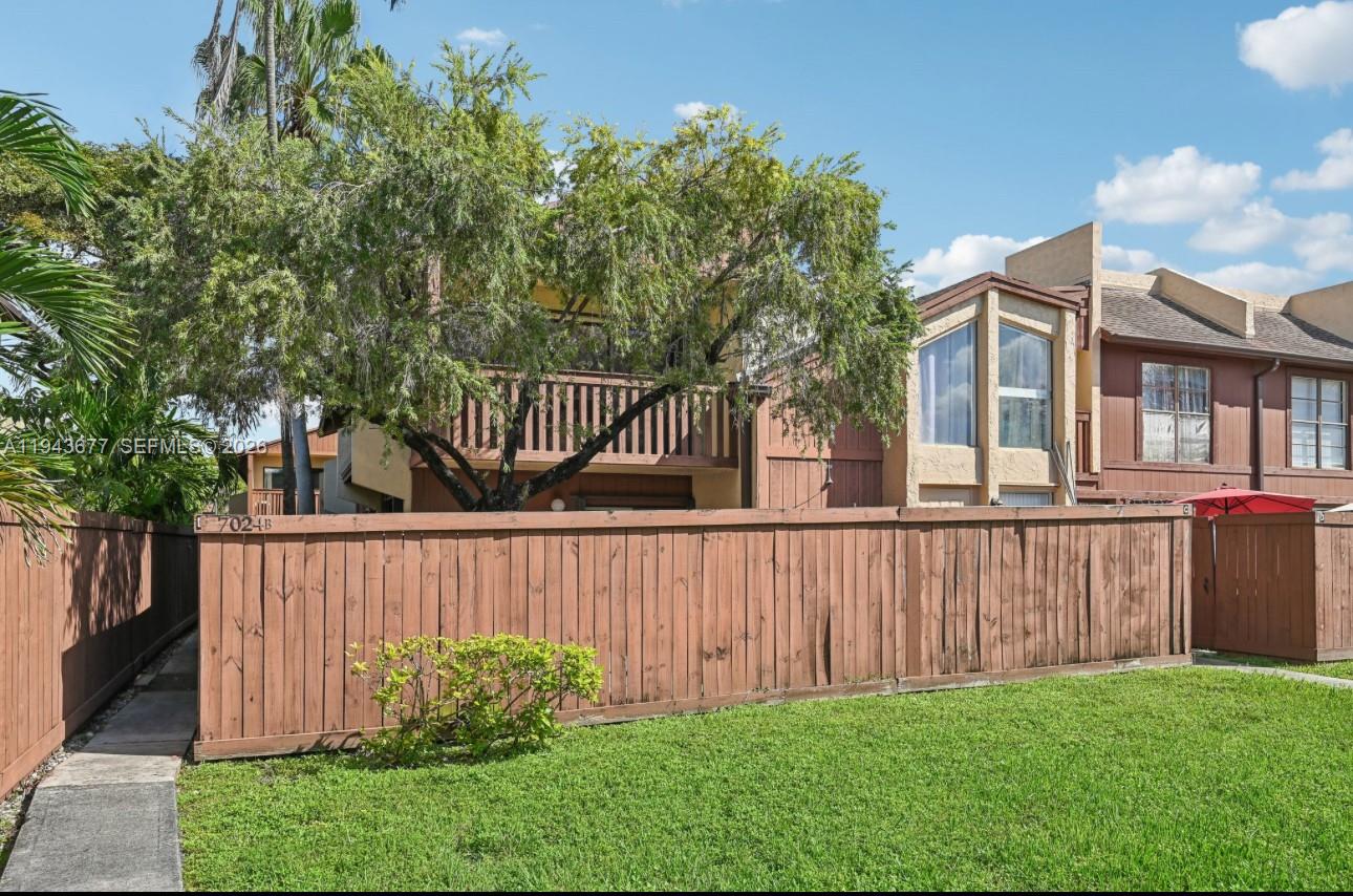 a view of a deck with a large trees and wooden fence