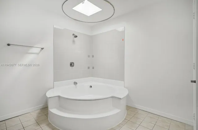 a view of a backyard with plants and large tree