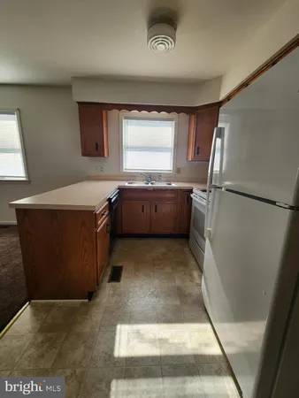 a room with granite countertop a sink a counter top space and stainless steel appliances